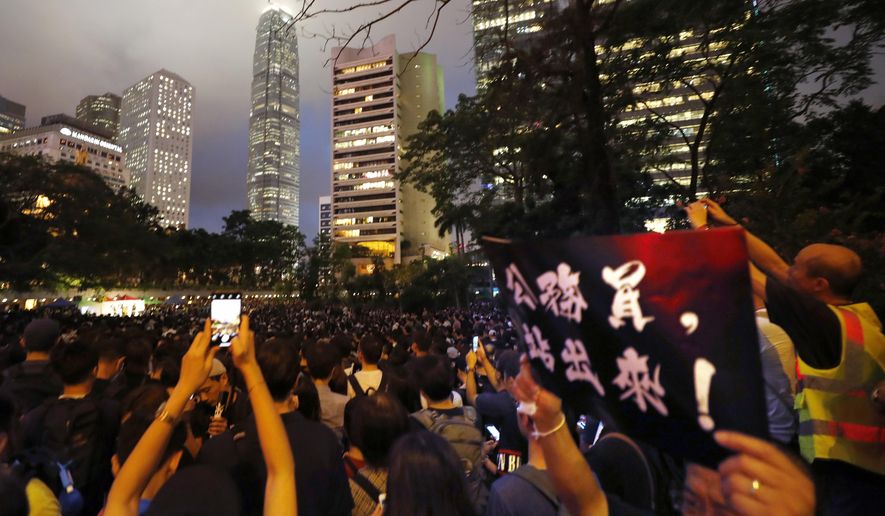 A man holds up a sign that reads: "Civil servants, stand out!" during a demonstration in Hong Kong Friday, Aug. 2, 2019. Protesters plan to return to the streets again this weekend, angered by the government's refusal to answer their demands, violent tactics used by police - possibly in coordination with organized crime figures. (AP Photo/Vincent Thian)