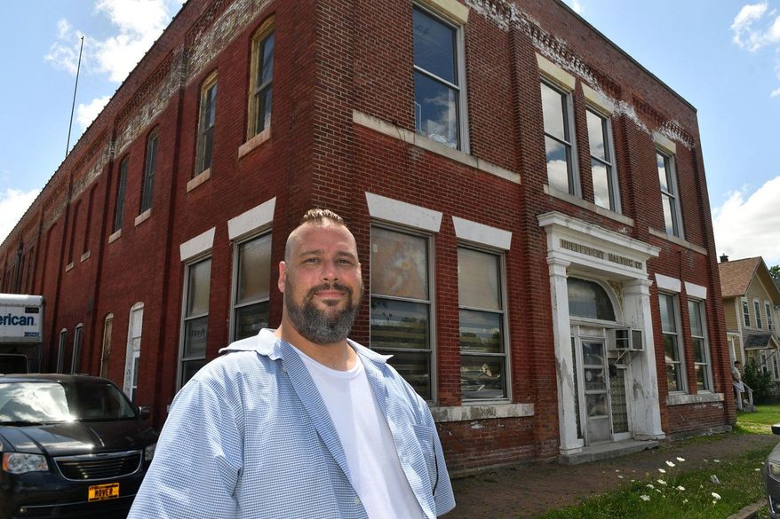 In this Monday, July 15, 2019 photo, Andrew Arnold stands in front of the Independent Malting Company in Davenport, Iowa. Arnold loves local history and good beer. The 42-year-old Davenport native is mixing those passions in an intoxicating plan to create a new $2.5 million craft brewery, museum and tasting room at the site of what was once Iowa's largest brewery, Independent Malting Company. (Gary Kranbeck/Quad City Times via AP)