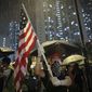 A protester waves a U.S. flag as hundreds of protesters gather outside Kwai Chung police station in Hong Kong, Tuesday, July 30, 2019. Protesters clashed with police again in Hong Kong on Tuesday night after reports that some of their detained colleagues would be charged with the relatively serious charge of rioting. (AP Photo/Vincent Yu)