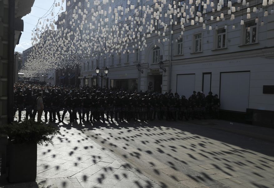 Police block a street during an unsanctioned rally in the center of Moscow, Russia, Saturday, July 27, 2019. Police clashed with demonstrators and have arrested some hundreds in central Moscow during a protest demanding that opposition candidates be allowed to run for the Moscow city council. (AP Photo/Pavel Golovkin)