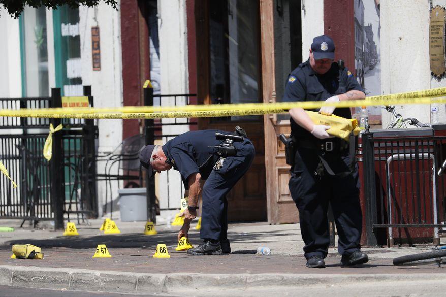 Authorities retrieve evidence markers at the scene of a mass shooting, Sunday, Aug. 4, 2019, in Dayton, Ohio. Multiple people in Ohio have been killed in the second mass shooting in the U.S. in less than 24 hours, and the suspected shooter is also deceased, police said. (AP Photo/John Minchillo)