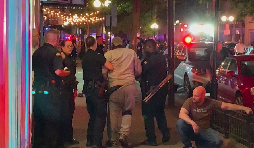 In this image made from video provided by Jeff Oaks, first responders help walk an injured person after a deadly shooting in Dayton, Ohio, Sunday, Aug. 4, 2019. A gunman in body armor opened fire early Sunday in a popular entertainment district in Dayton, Ohio, killing several people, including his sister, and wounding dozens of others before he was quickly slain by police, city officials said. (Jeff Oaks via AP)