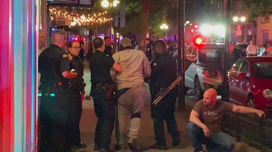 In this image made from video provided by Jeff Oaks, first responders help walk an injured person after a deadly shooting in Dayton, Ohio, Sunday, Aug. 4, 2019. A gunman in body armor opened fire early Sunday in a popular entertainment district in Dayton, Ohio, killing several people, including his sister, and wounding dozens of others before he was quickly slain by police, city officials said. (Jeff Oaks via AP)