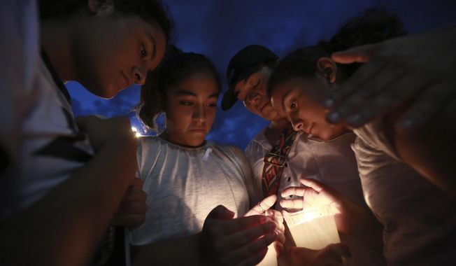 People gather in Juarez, Mexico, Saturday, Aug. 3, 2019, in a vigil for the three Mexican nationals who were killed in an El Paso shopping-complex shooting. Twenty people were killed and more than two dozen injured in a shooting Saturday in a busy shopping area in the Texas border town of El Paso, the state’s governor said. (AP Photo/Christian Chavez)
