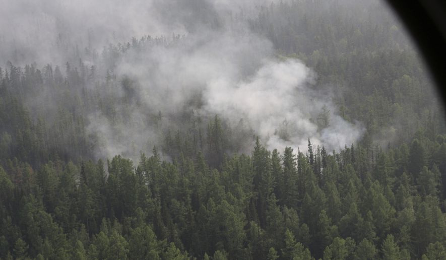 This photo taken on Monday, July 29, 2019, file and released by Press Service of the Ministry of Forestry of the Krasnoyarsk Territory, shows an air view of a forest fire in the Boguchansk district of the Krasnoyarsk region, Russia Far East. Hundreds of Russian towns and cities are shrouded in heavy smoke from wildfires in Siberia and the Far East Thursday, and the blazes appear to be spreading in remote terrain. (Maria Khlystunova, Press Service of the Ministry of Forestry of the Krasnoyarsk Territory via AP) ** FILE **