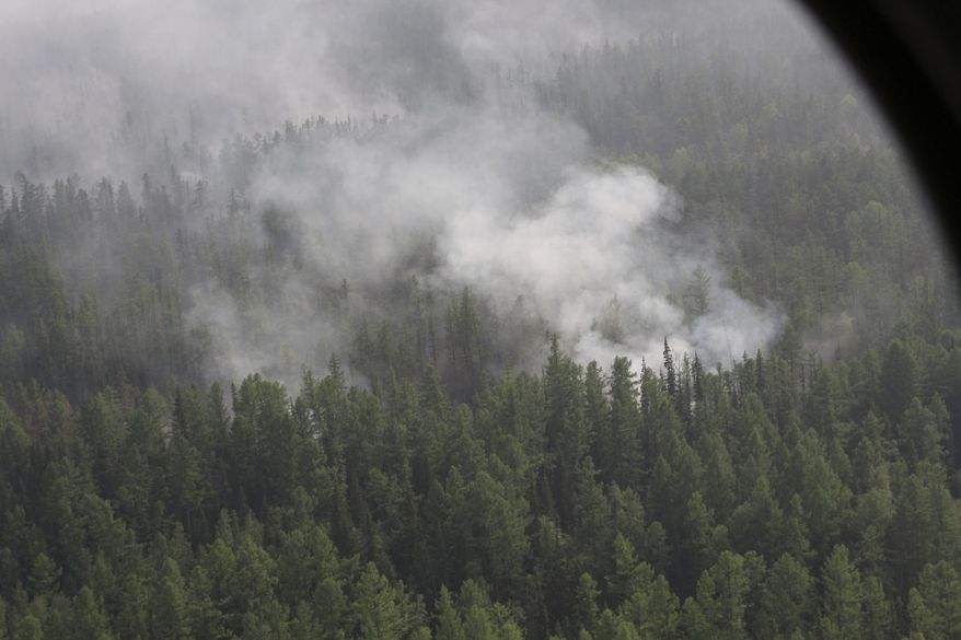This photo taken on Monday, July 29, 2019, file and released by Press Service of the Ministry of Forestry of the Krasnoyarsk Territory, shows an air view of a forest fire in the Boguchansk district of the Krasnoyarsk region, Russia Far East. Hundreds of Russian towns and cities are shrouded in heavy smoke from wildfires in Siberia and the Far East Thursday, and the blazes appear to be spreading in remote terrain. (Maria Khlystunova, Press Service of the Ministry of Forestry of the Krasnoyarsk Territory via AP) ** FILE **