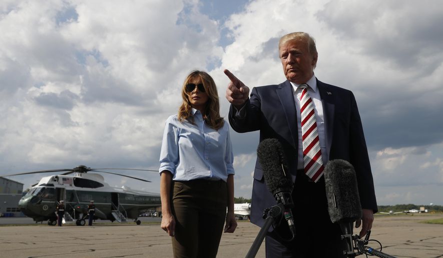 President Donald Trump, with first lady Melania Trump, speaks to the media before boarding Air Force One in Morristown, N.J., Sunday, Aug. 4, 2019. (AP Photo/Jacquelyn Martin)