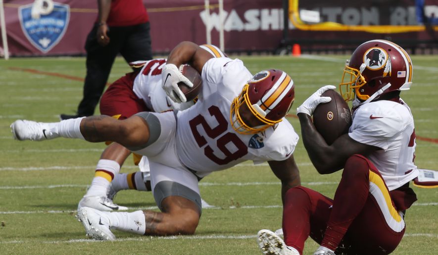 Washington Redskins running backs Shaun Wilson, right, and Derrius Guice (29) run drills during NFL football training camp in Richmond, Va., Monday, Aug. 5, 2019. (AP Photo/Steve Helber) **FILE**