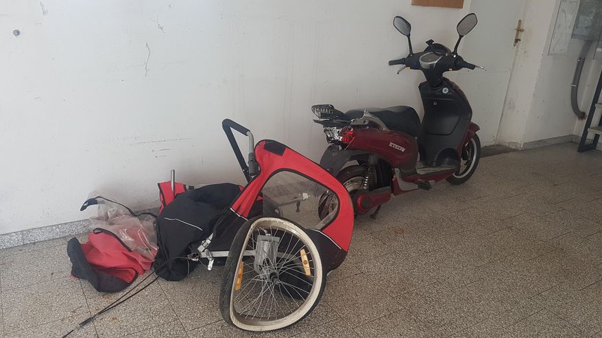 In this photo provided by the Landespolizeidirektion Niederoesereich, County Police of Lower Austria, on Monday Aug. 5, 2019, shows the destroyed trailer behind an electric moped after a fatal accident leaving two children dead near the town of Hausleiten, northwest of Vienna. Austrian police say two young girls aged one and four have died after a driver slammed into the trailer being pulled in behind their mother's electric moped. (Landespolizeidirektion Niederoestereich/handout via AP)