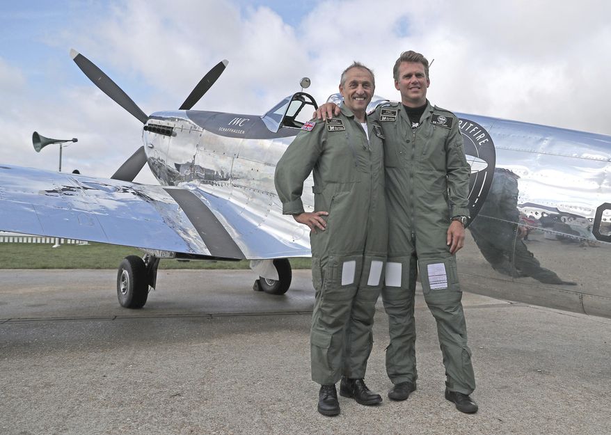 IWC Silver Spitfire pilots Matt Jones, right, and Steve Boultbee Brooks with their newly restored MK IX Spitfire at Goodwood Aerodrome in Goodwood, England, Monday, Aug. 5, 2019. A restored World War II Spitfire has taken off from an English aerodrome on the first leg of a planned 27,000 mile (43,000 kilometer) trip around the globe. Pilots Steve Brooks and Matt Jones hope to circle the world in about four months, with stops in 30 countries. Brooks says his biggest worry was the weather - and “landing is always the tricky part.” (Steve Parsons/PA via AP)
