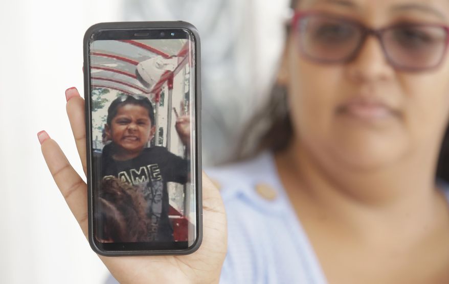 FILE - In this July 29, 2019 file photo Josephine Guicho holds her phone showing a photo of her 6-year-old nephew Stephen Romero in San Jose, Calif. The Santa Clara County coroner's office says two of the victims of the Gilroy Garlic Festival shooting died of gunshot wounds to their chests and a third died of a back wound. The office of the medical examiner-coroner says Monday, Aug. 5, 2019, the deaths of Romero, Trevor Irby, Keyla Salazar are classified as homicides. (AP Photo/Jeff Chiu,File)