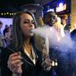 In this Dec. 31, 2013, photo, a woman smokes marijuana during a Prohibition-era-themed New Year&#39;s Eve party at a bar in Denver, the day before Colorado allowed retail sales of marijuana to those 21 and over.  (AP Photo/Brennan Linsley) **FILE**