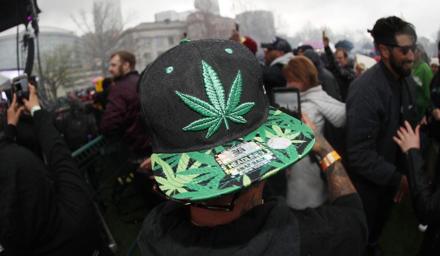 In this April 20, 2018, file photo, an attendee celebrates at 4:20 p.m. by lighting up marijuana during the Mile High 420 Festival in Denver. (AP Photo/David Zalubowski) ** FILE **