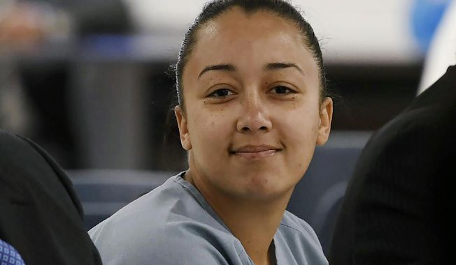 In this May 23, 2018, file pool photo, Cyntoia Brown, a woman serving a life sentence for killing a man when she was a 16-year-old prostitute, smiles at family members during her clemency hearing at Tennessee Prison for Women in Nashville, Tenn. (Lacy Atkins/The Tennessean via AP, Pool, File)