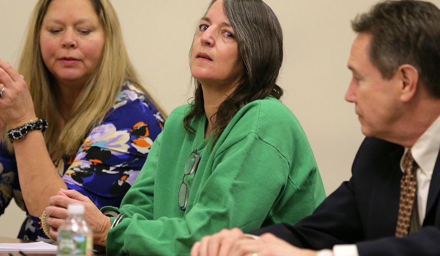 FILE - In a Thursday, Jan. 5, 2017 file photo, Michelle Lodzinski, sits with Chris Davitt, left, and her defense attorney Gerald Krovatin during her sentencing hearing, where she was sentenced to 30 years for the 1991 murder of her 5 year-old son Timothy Wiltsey, at Middlesex County Court in New Brunswick, N.J. A state appeals court on Wednesday, July 7, 2019 declined to toss the conviction of Michelle Lodzinski, convicted of killing her young son in 1991, ruling that prosecutors presented sufficient evidence to prove her guilt and the trial judge didn't err by dismissing a juror during deliberations.(Tanya Breen/The Asbury Park Press via AP, Pool, File)
