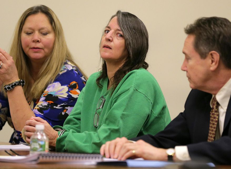 FILE - In a Thursday, Jan. 5, 2017 file photo, Michelle Lodzinski, sits with Chris Davitt, left, and her defense attorney Gerald Krovatin during her sentencing hearing, where she was sentenced to 30 years for the 1991 murder of her 5 year-old son Timothy Wiltsey, at Middlesex County Court in New Brunswick, N.J. A state appeals court on Wednesday, July 7, 2019 declined to toss the conviction of Michelle Lodzinski, convicted of killing her young son in 1991, ruling that prosecutors presented sufficient evidence to prove her guilt and the trial judge didn't err by dismissing a juror during deliberations.(Tanya Breen/The Asbury Park Press via AP, Pool, File)