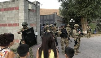 Kyrgyz special forces stand in guard at former president of Kyrgyzstan Almazbek Atambayev&#39;s residence in the village of Koi-Tash, about 20 kilometers (12 miles) south of the capital, Bishkek, Kyrgyzstan, Wednesday, Aug. 7, 2019. Gunfire is being heard outside the residence of the former president of Kyrgyzstan as police move in to try to arrest him. The Kyrgyz news site 24.kg said several people, including journalists, have been wounded in the Wednesday shooting in the village of Koi-Tash, 20 kilometers (12 miles) south of the capital, Bishkek. (AKIpress via AP)