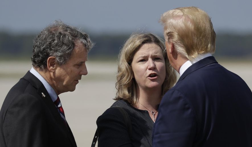 President Donald Trump is greeted by Dayton Mayor Nan Whaley and Sen. Sherrod Brown, D-Ohio, after arriving at Wright-Patterson Air Force Base to meet with people affected by the mass shooting in Dayton, Wednesday, Aug. 7, 2019, in Wright-Patterson Air Force Base, Ohio. (AP Photo/Evan Vucci)