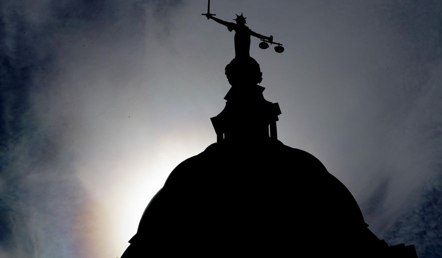 A statue of liberty is silhouetted as it stands atop the Old Bailey, Central Criminal Court, in London, Thursday, Aug. 8, 2019. A 17-year old boy will appear at The Old Bailey charged with attempted murder of a young boy aged six who was thrown off a balcony at the Tate Modern art gallery on Sunday Aug. 4.(AP Photo/Frank Augstein)