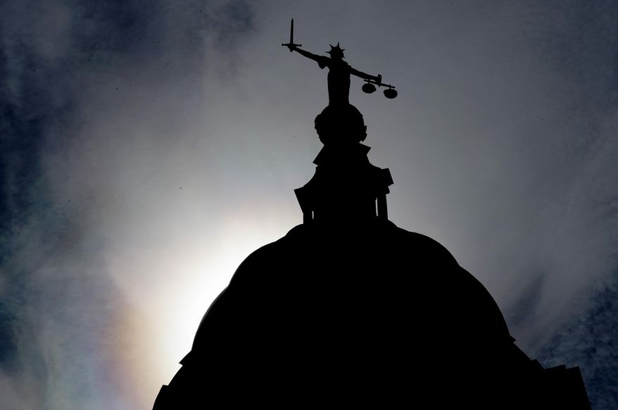 A statue of liberty is silhouetted as it stands atop the Old Bailey, Central Criminal Court, in London, Thursday, Aug. 8, 2019. A 17-year old boy will appear at The Old Bailey charged with attempted murder of a young boy aged six who was thrown off a balcony at the Tate Modern art gallery on Sunday Aug. 4.(AP Photo/Frank Augstein)