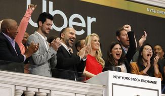 FILE - In this May 10, 2019, file photo Uber CEO Dara Khosrowshahi, third from left, attends the opening bell ceremony at the New York Stock Exchange, as his company makes its initial public offering. Uber reports financial results Thursday, Aug. 8. (AP Photo/Richard Drew, File)