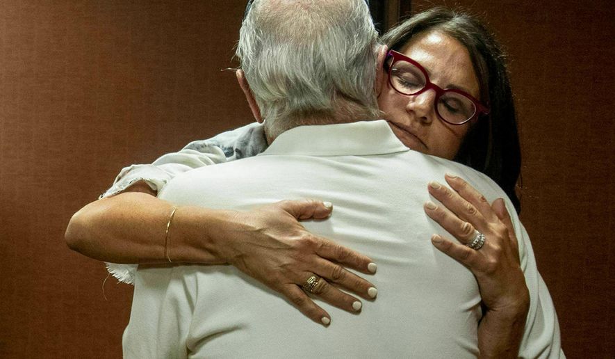 FILE - In this July 11, 2019 file photo, Tanya Gersh, a Montana real estate agent, embraces her father Lloyd Rosenstein following a hearing at the Russell Smith Federal Courthouse in Missoula. A Montana judge has ordered the publisher of a neo-Nazi website to pay Gersh over $14 million for encouraging his readers to harass her and her family. U.S. District Judge Dana Christensen on Thursday, Aug. 8, 2019 also ordered The Daily Stormer founder Andrew Anglin to permanently remove all posts, comments and images about Gersh, her husband and son. (Ben Allen/The Missoulian via AP, File)