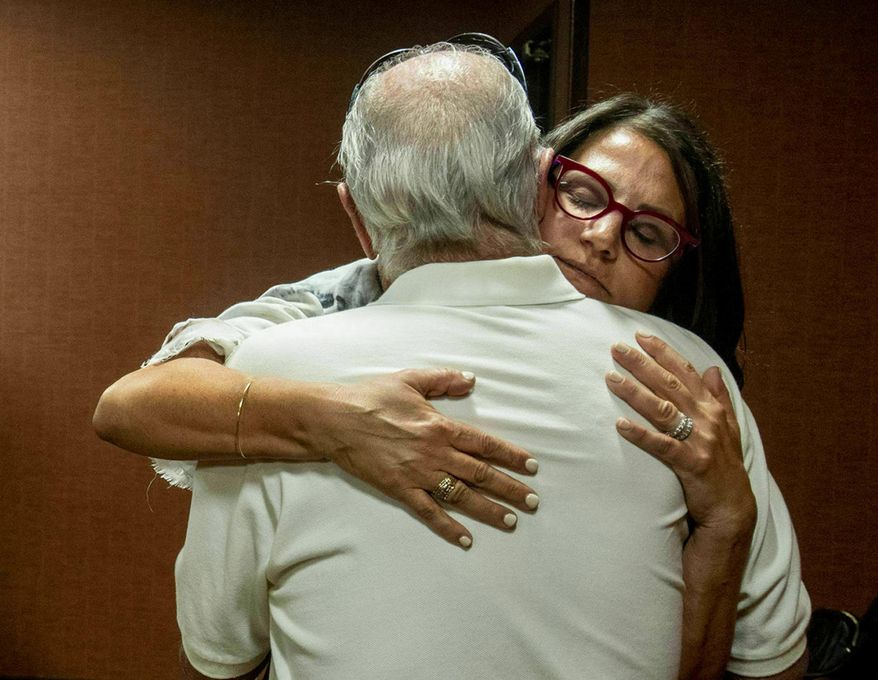 FILE - In this July 11, 2019 file photo, Tanya Gersh, a Montana real estate agent, embraces her father Lloyd Rosenstein following a hearing at the Russell Smith Federal Courthouse in Missoula. A Montana judge has ordered the publisher of a neo-Nazi website to pay Gersh over $14 million for encouraging his readers to harass her and her family. U.S. District Judge Dana Christensen on Thursday, Aug. 8, 2019 also ordered The Daily Stormer founder Andrew Anglin to permanently remove all posts, comments and images about Gersh, her husband and son. (Ben Allen/The Missoulian via AP, File)