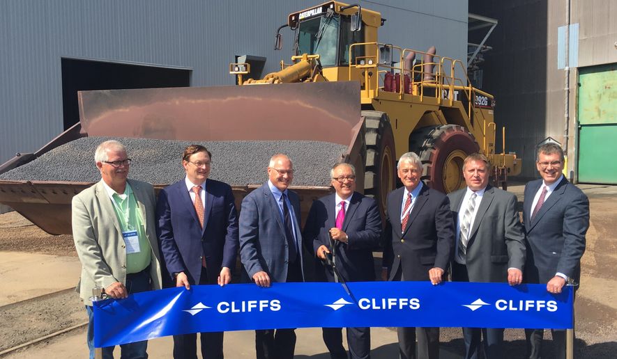Cleveland Cliffs CEO Lourenco Goncalves, flanked by current 8th District Congressman Pete Stauber and former Congressman Rick Nolan, cuts the ceremonial ribbon on Tuesday, Aug. 6, 2019, for Northshore Mining's $100 million upgrade to produce a new kind of iron pellet to feed a growing segment of the steel industry. (Dan Kraker/Minnesota Public Radio via AP)