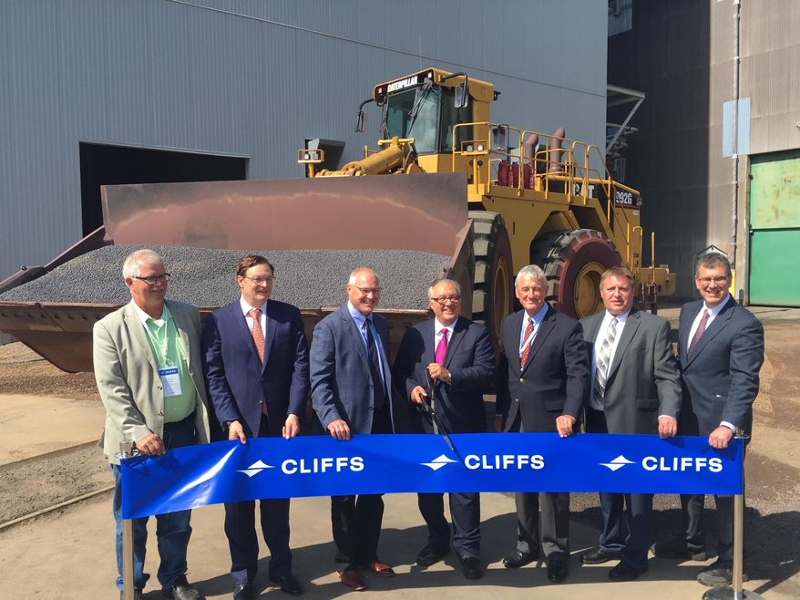 Cleveland Cliffs CEO Lourenco Goncalves, flanked by current 8th District Congressman Pete Stauber and former Congressman Rick Nolan, cuts the ceremonial ribbon on Tuesday, Aug. 6, 2019, for Northshore Mining's $100 million upgrade to produce a new kind of iron pellet to feed a growing segment of the steel industry. (Dan Kraker/Minnesota Public Radio via AP)