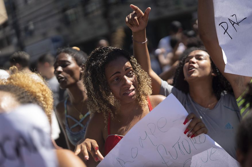 A woman cries as she attends a protest after student Gabriel Pereira Alves was killed by a stray bullet on his way to school in Rio de Janeiro, Brazil, Friday, Aug. 9, 2019. A police statement said officers of a small unit stationed in the favela were attacked by criminals Friday morning but did not respond. Several residents, however, told The Associated Press there had been an exchange of fire between criminals and the police. (AP Photo/Leo Correa)