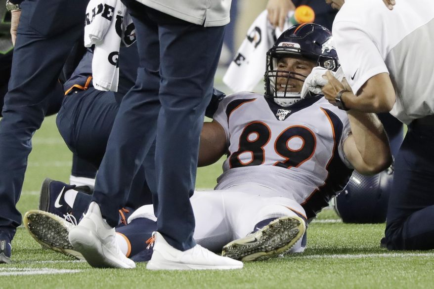 Denver Broncos tight end Austin Fort is helped up after an injury on a reception during the second half of the team's NFL football preseason game against the Seattle Seahawks, Thursday, Aug. 8, 2019, in Seattle. (AP Photo/Elaine Thompson)