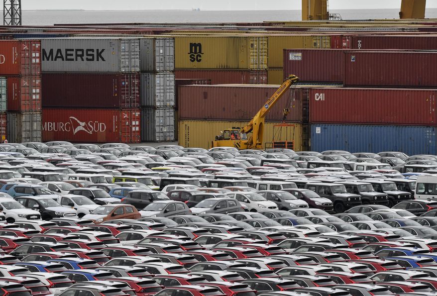 File - In this Thursday, May 16, 2019, file photo, cars for export and import are stored in front of containers at the port in Bremerhaven, Germany. In June 2019 German industrial production dropped significantly for the second time in three months. (AP Photo/Martin Meissner)