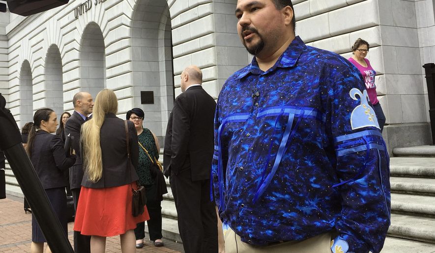 FILE - In this Wednesday, March 13, 2019, file photo, Tehassi Hill, tribal chairman of the Oneida Nation, stands outside a federal appeals court in New Orleans, following arguments on the constitutionality of a 1978 law giving Native American families preference in adoption of Native American children. On Friday, Aug. 9, 2019, the 5th U.S. Circuit Court of Appeals in New Orleans upheld the constitutionality of the law. (AP Photo/Kevin McGill, File)