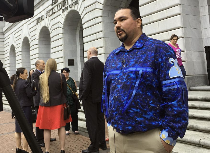 FILE - In this Wednesday, March 13, 2019, file photo, Tehassi Hill, tribal chairman of the Oneida Nation, stands outside a federal appeals court in New Orleans, following arguments on the constitutionality of a 1978 law giving Native American families preference in adoption of Native American children. On Friday, Aug. 9, 2019, the 5th U.S. Circuit Court of Appeals in New Orleans upheld the constitutionality of the law. (AP Photo/Kevin McGill, File)