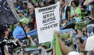 In this July 21, 2019, photo, a sign that reads &amp;quot;Anti-Facist Always Seattle Anti-Racist&amp;quot; is displayed in the supporters section during an MLS soccer match between the Seattle Sounders and the Portland Timbers in Seattle. Major League Soccer&#39;s new policy that bans political displays at matches is drawing attention in the Pacific Northwest, where supporters&#39; culture is often intertwined with politics and social issues. (AP Photo/Ted S. Warren)
