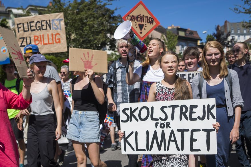 Swedish climate activist Greta Thunberg reacts with other young climate activists during a demonstration against climate change on the closing day of the «' Smile for Future Summit for climate' », in Lausanne, Switzerland, Friday, Aug. 9, 2019. More than 450 participants from 37 different countries met this week in Lausanne for the summer gathering of the «' Fridays for Future' » movement. (Jean-Christophe Bott/Keystone via AP)