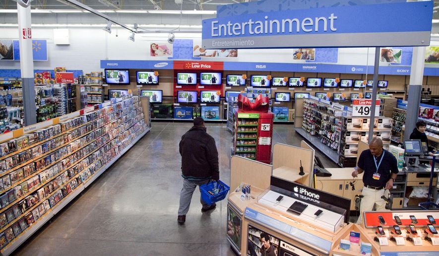 In this Dec. 15, 2010 file photo, a view of the entertainment section of a Wal-Mart store is seen in Alexandria, Va.  Walmart is taking down all signs and displays from its stores that depict violence, following a mass shooting at its El Paso, Texas location that left 22 people dead. The retailer, according to an internal memo, instructed employees to turn off or unplug any video game consoles that show  violent games, as well as ensure that no movies depicting violence are playing in its electronics departments.   (AP Photo, File)