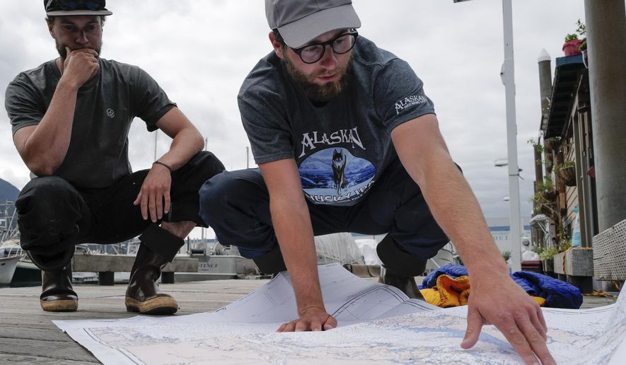 In this Thursday, Aug. 2, 2019 photo, Liam Godfrey-Jolicoeur, left, and Jake Dombek, talk at Harris Harbor in Juneau, Alaska, about their nearly two-month long trip up the Inside Passage by canoe. Both are originally from Vermont used the trip to raise money and bring awareness to environmental causes. (Michael Penn/Juneau Empire via AP)