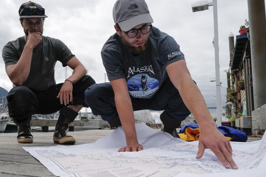 In this Thursday, Aug. 2, 2019 photo, Liam Godfrey-Jolicoeur, left, and Jake Dombek, talk at Harris Harbor in Juneau, Alaska, about their nearly two-month long trip up the Inside Passage by canoe. Both are originally from Vermont used the trip to raise money and bring awareness to environmental causes. (Michael Penn/Juneau Empire via AP)