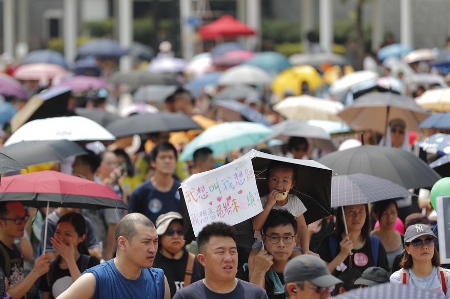 A child holds a sign that reads "I want to shout, I want to jump, I hope Hong Kong's future will continue" during a march billed as "Save our Children" in Hong Kong on Saturday, Aug. 10, 2019. China's central government has dismissed Hong Kong pro-democracy protesters as clowns and criminals while bemoaning growing violence surrounding the monthslong demonstrations. (AP Photo/Vincent Thian)