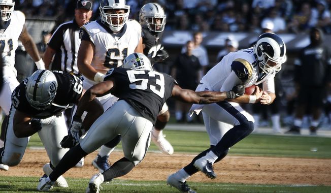 Los Angeles Rams quarterback Brandon Allen, right, evades a tackle by Oakland Raiders&#x27; Jason Cabinda (53) during the first half of a preseason NFL football game Saturday, Aug. 10, 2019, in Oakland, Calif. (AP Photo/Rich Pedroncelli)