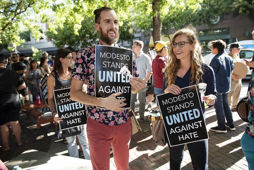 In this Wednesday, Aug. 7, 2019, photo Shaun Gepley, left, and Katy Forney, attend a rally to show their opposition to a straight pride rally planned for Graceada Park in Modesto, Calif. Dozens of people gathered before the Modesto City Council meeting at 10th Street Place in Modesto, Calif. (Andy Alfaro/The Modesto Bee via AP)