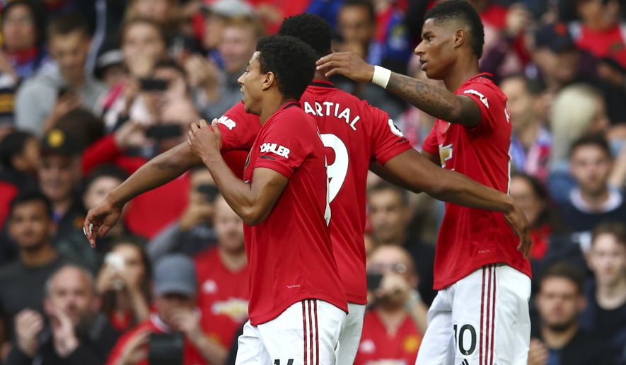 Manchester United&#39;s Marcus Rashford, right, celebrates with teammates after scoring his sides first goal during the English Premier League soccer match between Manchester United and Chelsea at Old Trafford in Manchester, England, Sunday, Aug. 11, 2019. (AP Photo/Dave Thompson)