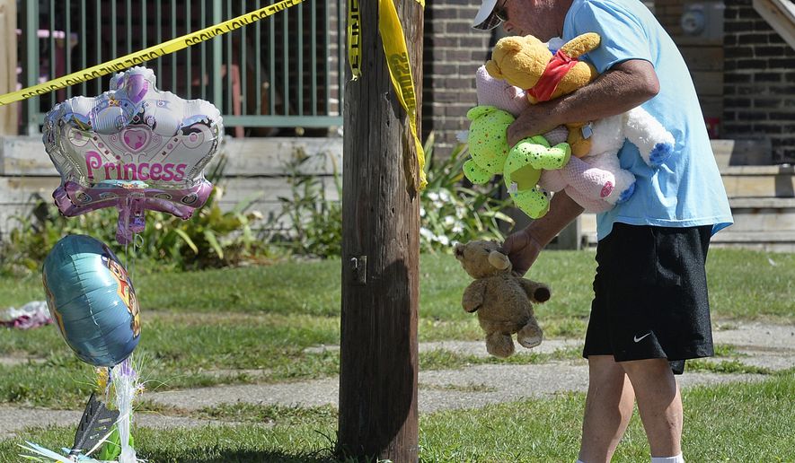 Paul Laughlin, 57, places stuffed animals on Sunday, Aug. 11, 2019 outside a home at 1248 West 11th St. in Erie, Pa., where multiple people died in an early-morning fire.   (Greg Wohlford/Erie Times-News via AP)
