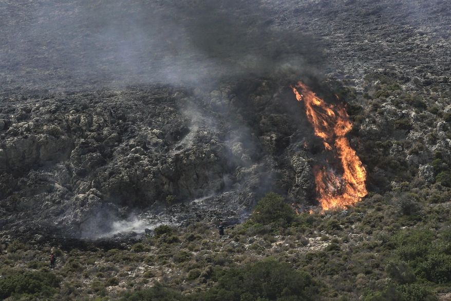 Firefighters approach a wildfire at Elafonisos island, south of Peloponnese peninsula, on Saturday, Aug. 10, 2019. A wildfire which broke out on Elafonisos island in southern Greece on Saturday has prompted the evacuation of a hotel and camping as a precautionary measure, with no injuries reported, according to Greek national news agency AMNA. (AP Photo/Nikolia Apostolou)