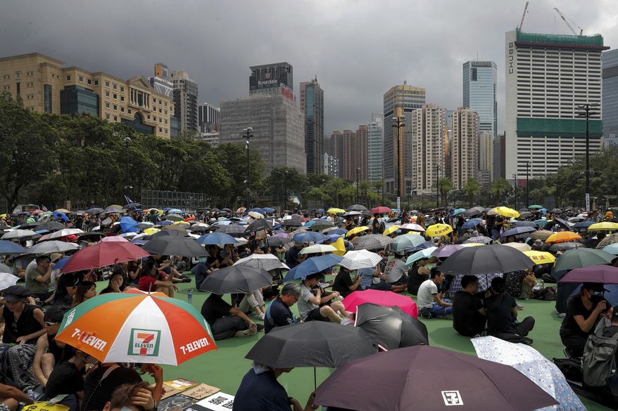 People holding umbrellas gather at Victoria Park to take part in an anti-extradition bill protest in Hong Kong, Sunday, Aug. 11, 2019. Protesters have begun gathering at the park in central Hong Kong for another day of demonstrations that have generally started peacefully but often ended in violent clashes with police. (AP Photo/Vincent Thian)