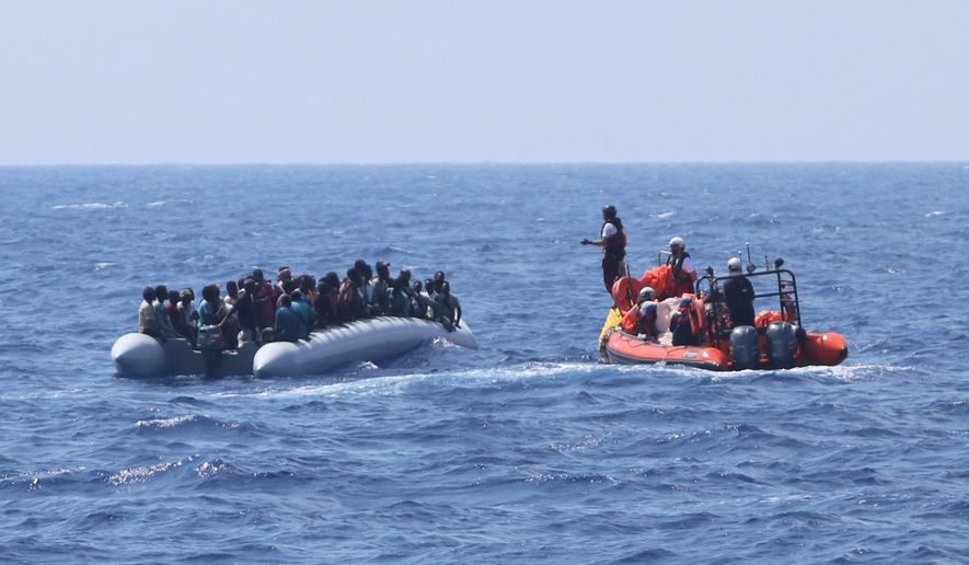 In this photo taken Saturday and released Sunday, Aug. 11, 2019, a rescue team of the Ocean Viking ship, operated by the NGOs Sos Mediterranee and Doctors Without Borders, approaches a rubber dinghy with over 80 migrants off the Libyan coast. The Ocean Viking was already carrying over 80 people rescued earlier, and is blocked at sea while it waits to be assigned a safe port. Italian Interior Minister Matteo Salvini, who has triggered a government crisis in Italy, signed Friday a ban on the ship's entry into Italian waters. (Hannah Wallace Bowman/MSF/Sos Mediterranee via AP)