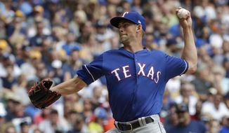 Texas Rangers starting pitcher Mike Minor throws during the first inning of a baseball game against the Milwaukee Brewers Sunday, Aug. 11, 2019, in Milwaukee. (AP Photo/Morry Gash)