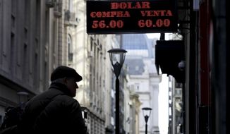 A man looks at a currency exchange board in Buenos Aires, Argentina, Monday, Aug. 12, 2019. Argentine stocks and currency plummeted on Monday after Argentine President Mauricio Macri was snubbed by voters who appeared to hand a resounding primary victory to a populist ticket with his predecessor, Cristina Fernández. (AP Photo/Natacha Pisarenko)