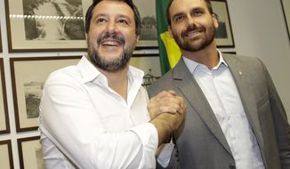 FILE - In this April 19, 2019 file photo, Eduardo Bolsonaro, right, son of Brazilian President Jair Bolsonaro, poses for a photo with Deputy Prime Minister Matteo Salvini at the consulate in Milan, Italy. Federal prosecutors in Brazil filed a motion Monday, Aug. 12, 2019, that could block Bolsonaro’s son from becoming ambassador to Washington. (AP Photo/Luca Bruno, File)
